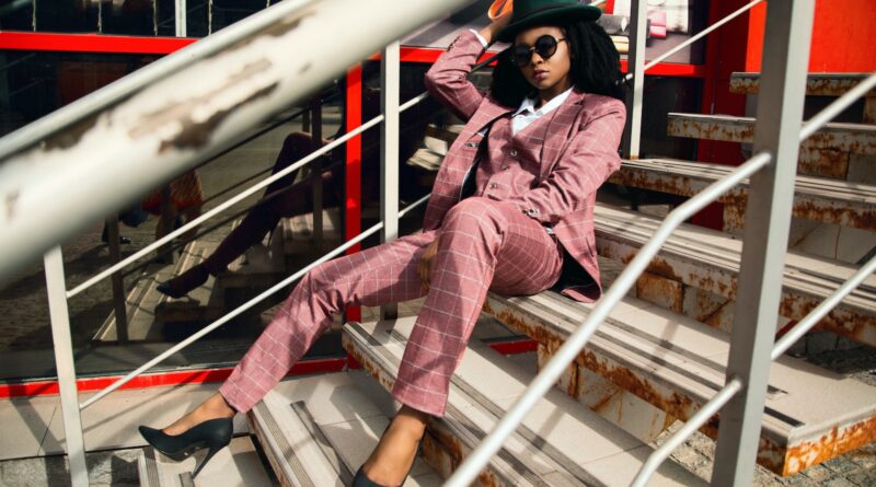 Woman Wearing Pink Suit Jacket and Pants Sitting on Staircase